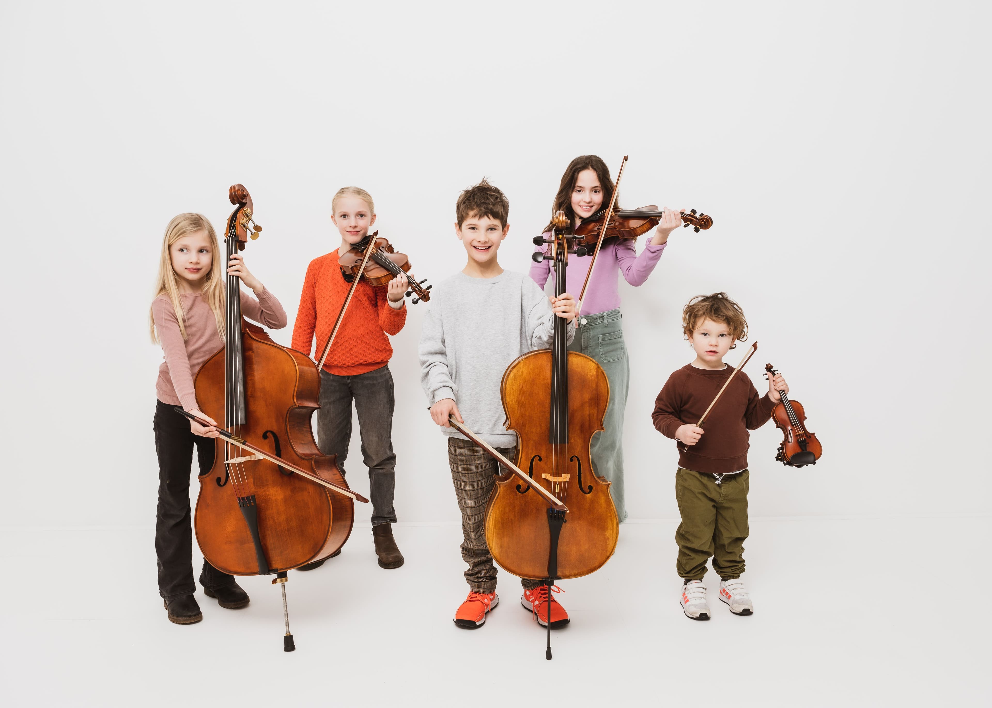 Fünf Kinder in verschiedenem Alter mit Streichinstrumenten