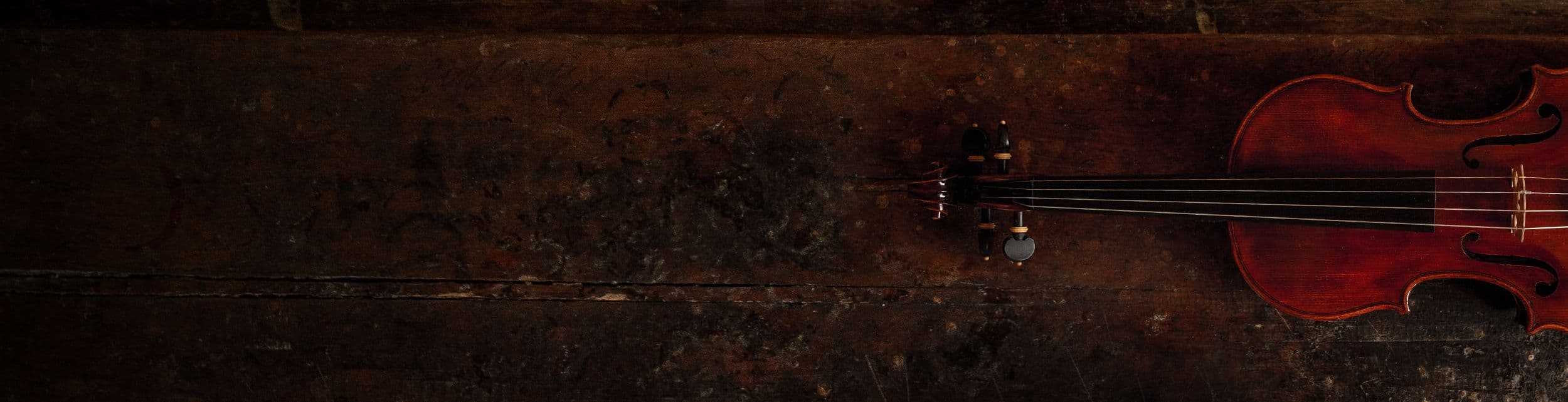 Auf einer alten Werkbank liegt eine Geige