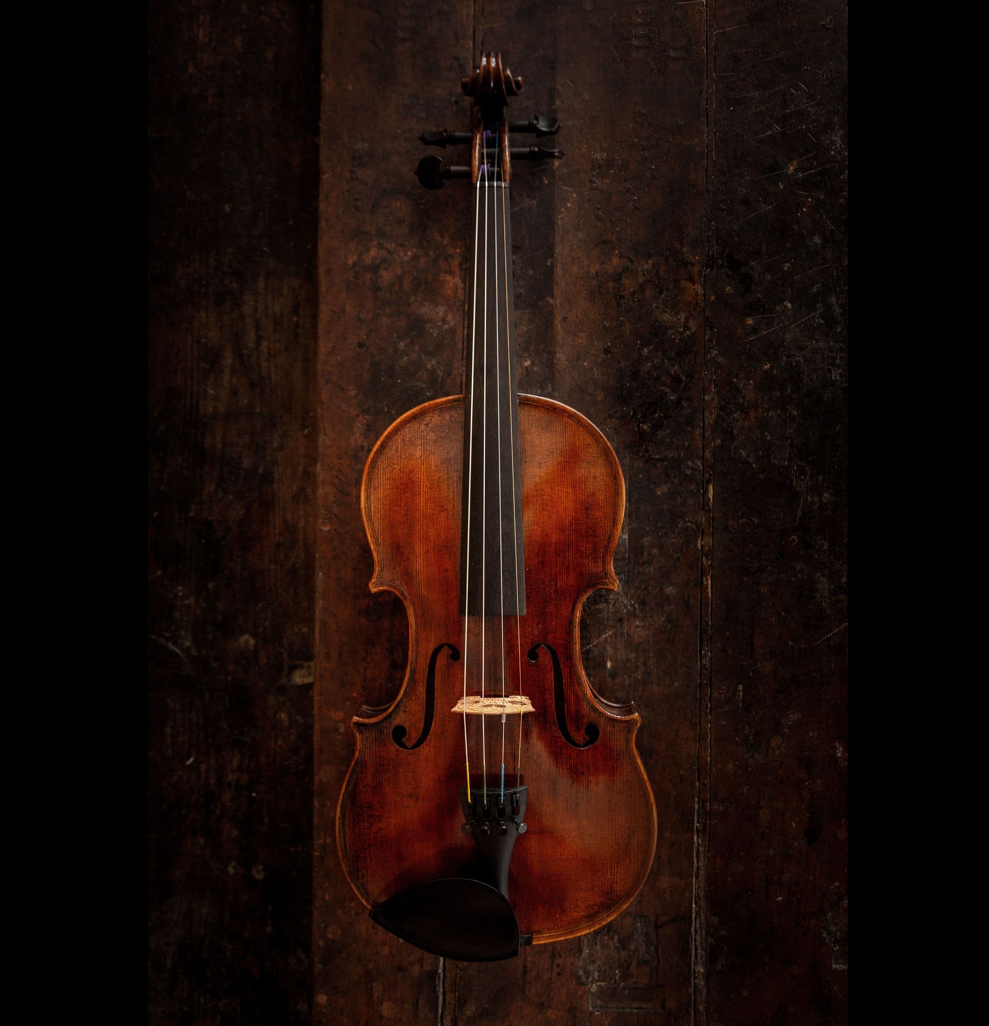 Eine Geige liegt auf einer Werkbank.