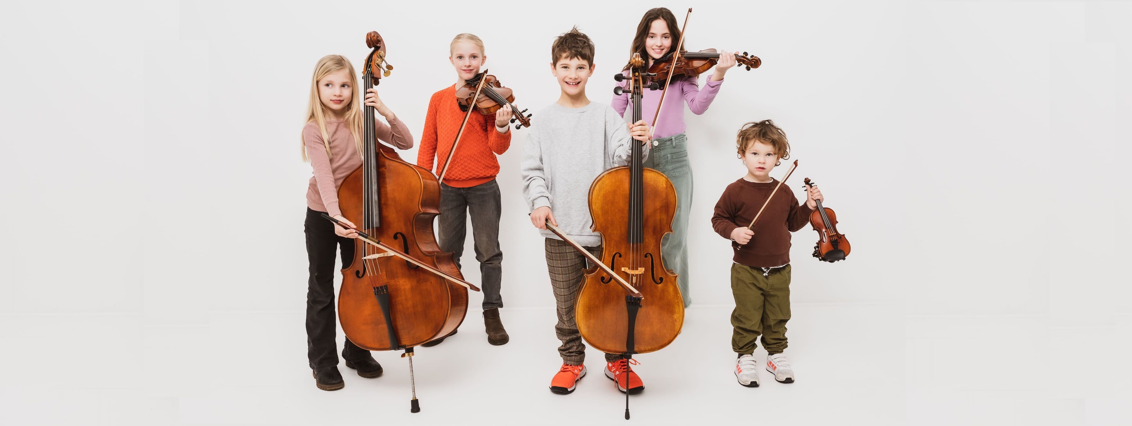 Fünf Kinder in verschiedenem Alter mit Streichinstrumenten